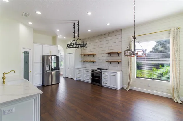 a dining room with wooden floor and windows