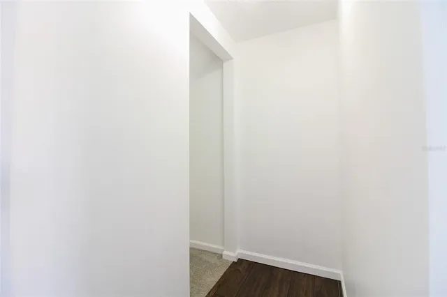 an empty room with windows and a ceiling fan