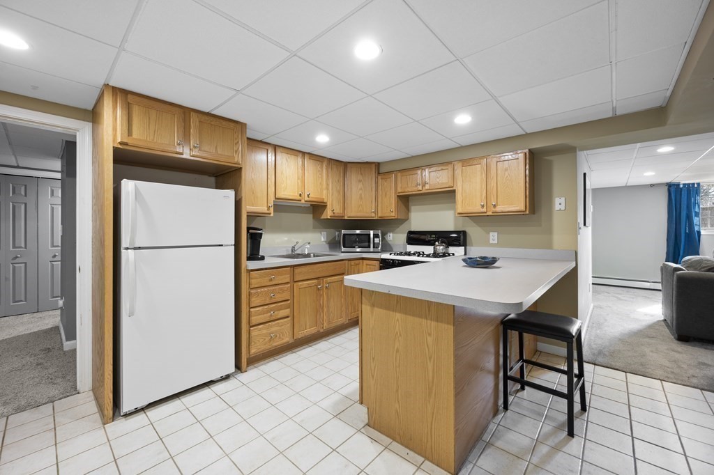 8 Penbrook Circle Andover, MA 01810 - Photo 31 of 42 a kitchen with granite countertop a refrigerator a stove a sink a dining table and chairs