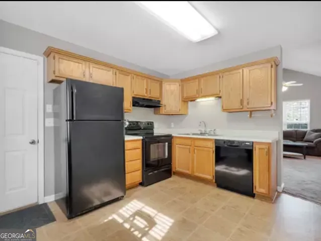 a kitchen with granite countertop a refrigerator and a stove top oven