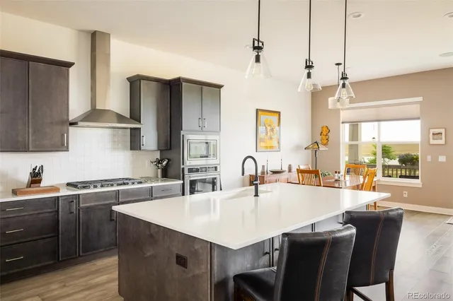 a kitchen with stainless steel appliances granite countertop a sink a stove and a refrigerator