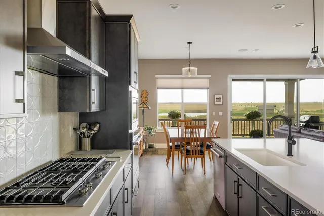 a kitchen with lots of counter top space a stove and a view of living room