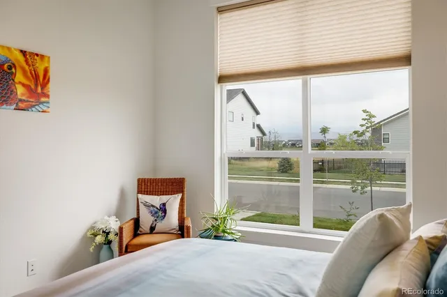 a bedroom with a bed and a large window