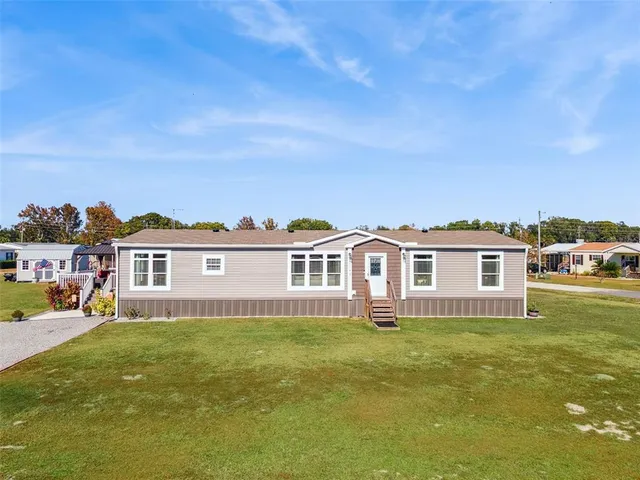 a front view of a house with a garden and plants