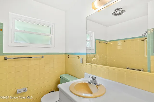 a view of a house with a yard and potted plants