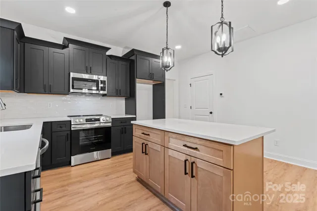 a kitchen with stainless steel appliances granite countertop a stove and a refrigerator