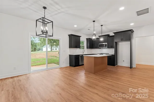 a view of kitchen with refrigerator microwave and wooden floor