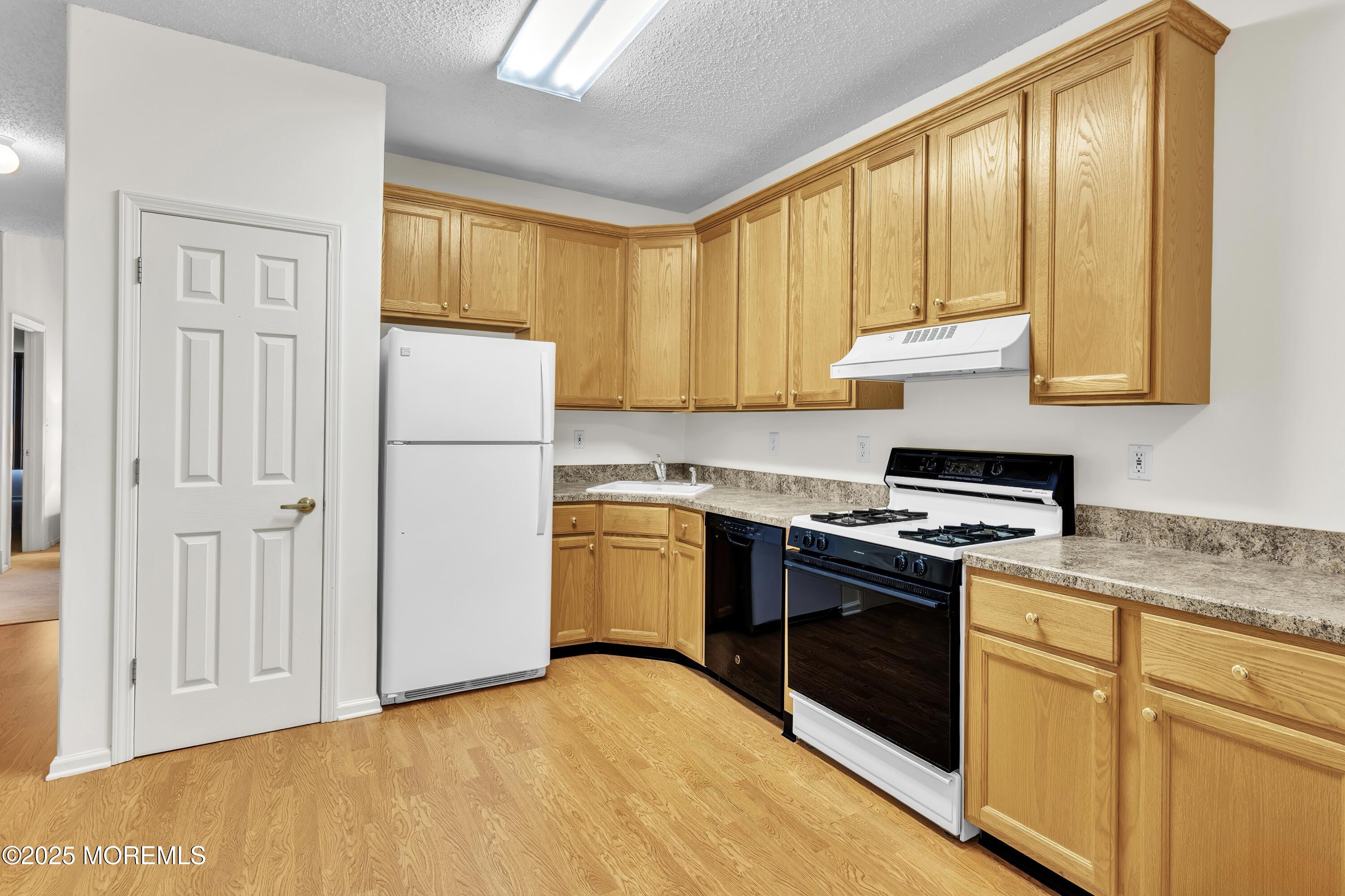 11 Riva Boulevard Brick, NJ 08723 - Photo 14 of 42 a kitchen with a refrigerator stove top oven and cabinets