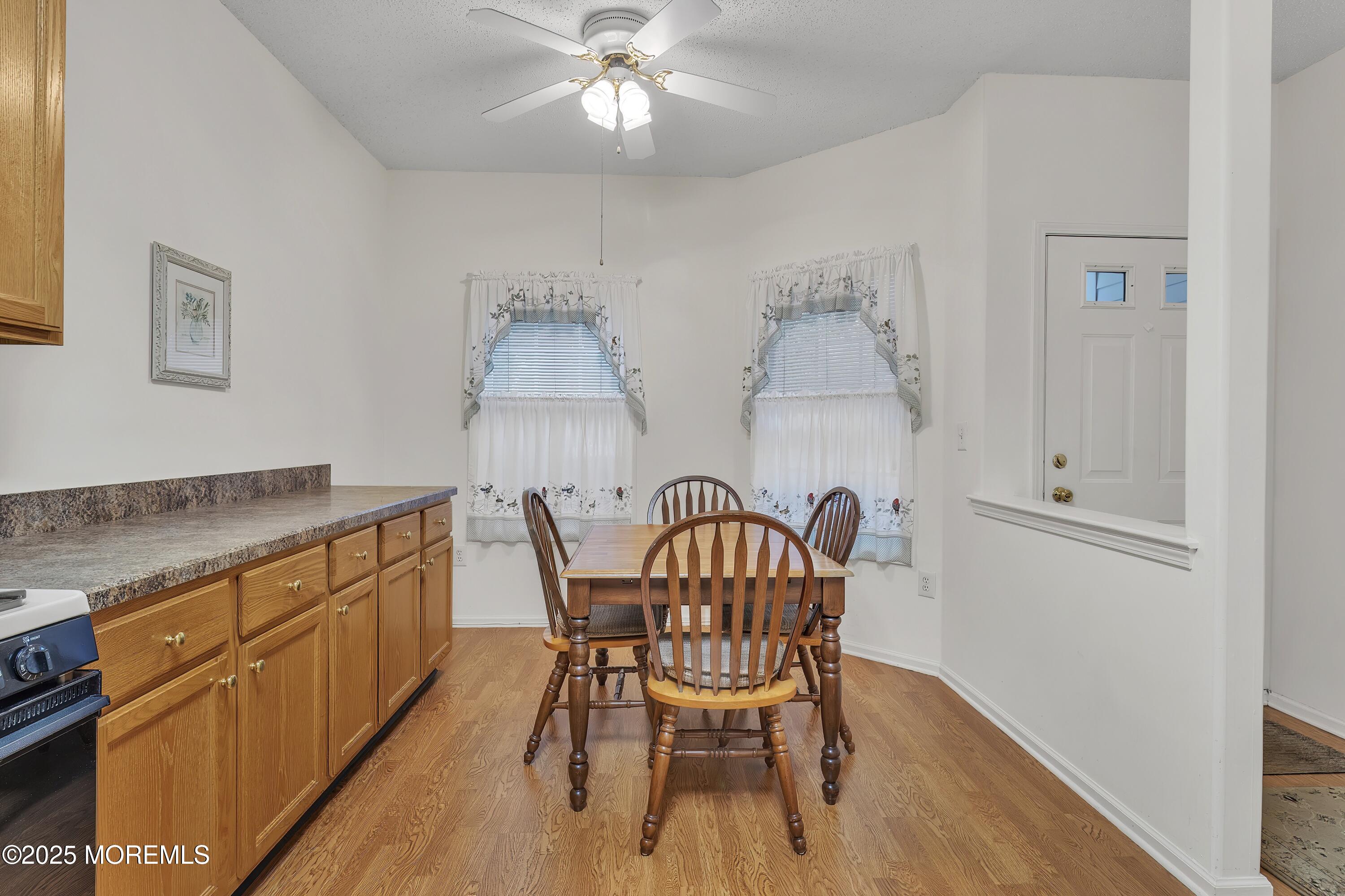 11 Riva Boulevard Brick, NJ 08723 - Photo 16 of 42 a kitchen with stainless steel appliances kitchen island granite countertop a table chairs in it and wooden floors