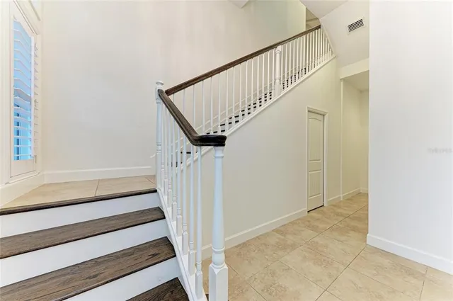 a kitchen with stainless steel appliances kitchen island granite countertop a refrigerator oven a sink dishwasher and white cabinets with wooden floor