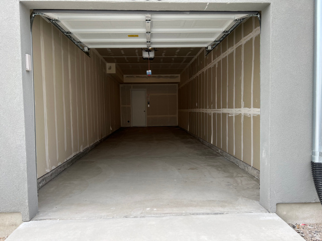 717 West W Coho Lane South, Unit 2F302 Midvale, UT 84047 - Photo 1 of 22 Spacious garage with concrete flooring, unfinished drywall, and an overhead garage door opener