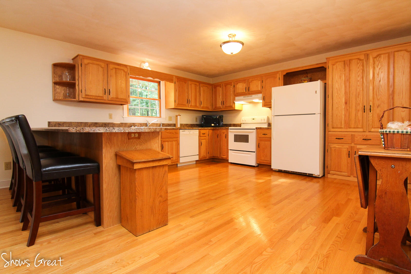 2507 Blue Ridge Springs Road Blue Ridge, VA 24064 - Photo 14 of 43 a kitchen with a refrigerator a stove top oven and a dining table with wooden floor