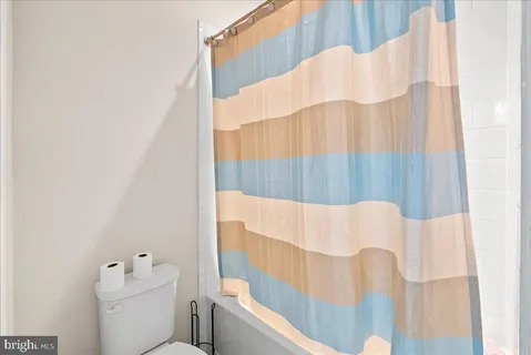 a bathroom with a white tub and a shower curtain
