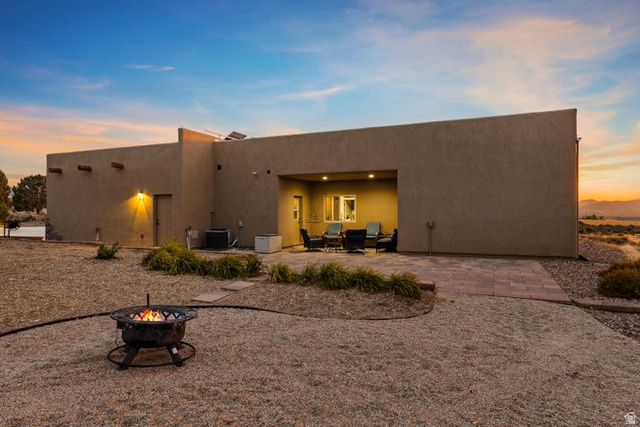 2925 Juniper Road Enterprise, UT 84725 - Photo 3 of 56 Rear view of house with a patio, stucco siding, and a fire pit