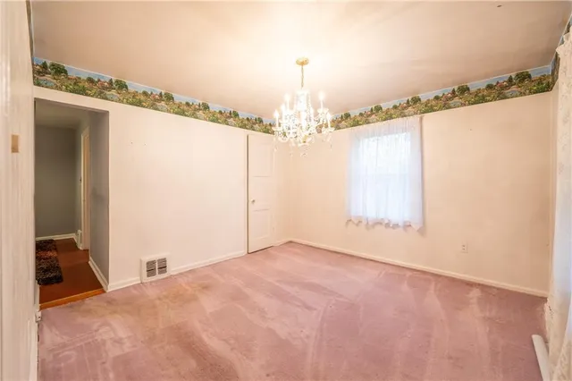 a view of a big room with chandelier and windows