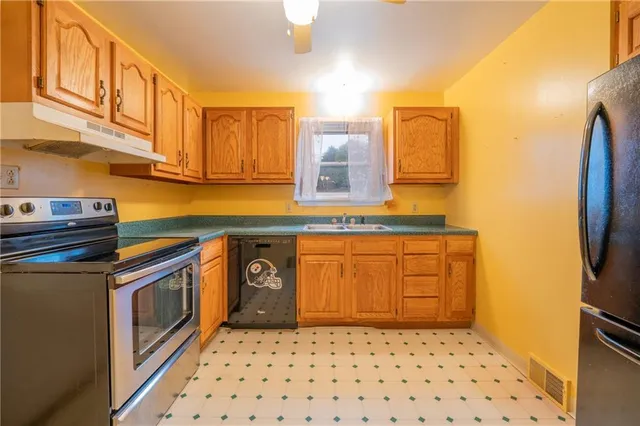 a kitchen with stainless steel appliances a sink and a refrigerator