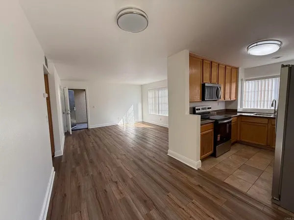 a kitchen with granite countertop wooden floors a stove and a refrigerator