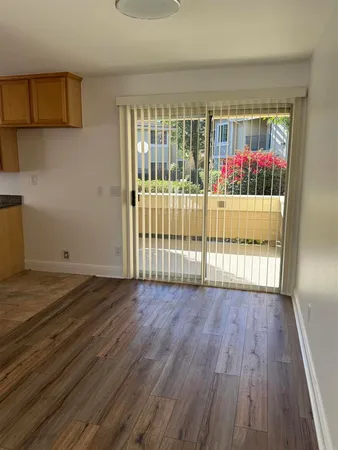 a kitchen with granite countertop a stove top oven cabinetry a sink and a window