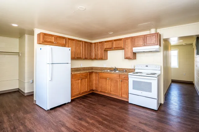 a kitchen with a refrigerator and a stove top oven