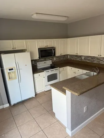 a kitchen with a stove a microwave and a refrigerator
