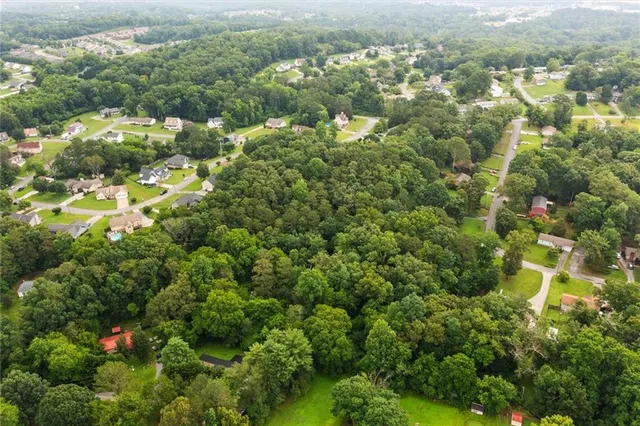 an aerial view of residential houses with outdoor space and trees