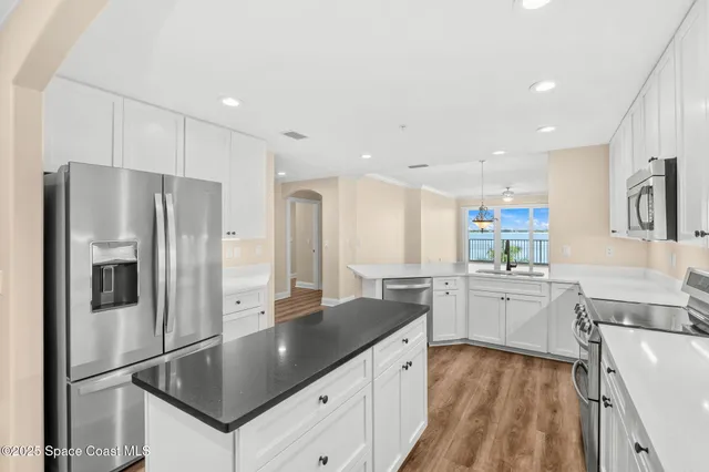 a kitchen with stainless steel appliances granite countertop a sink refrigerator and cabinets