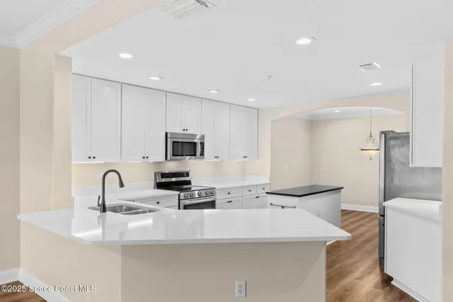 a kitchen with stainless steel appliances sinks a stove and a sink