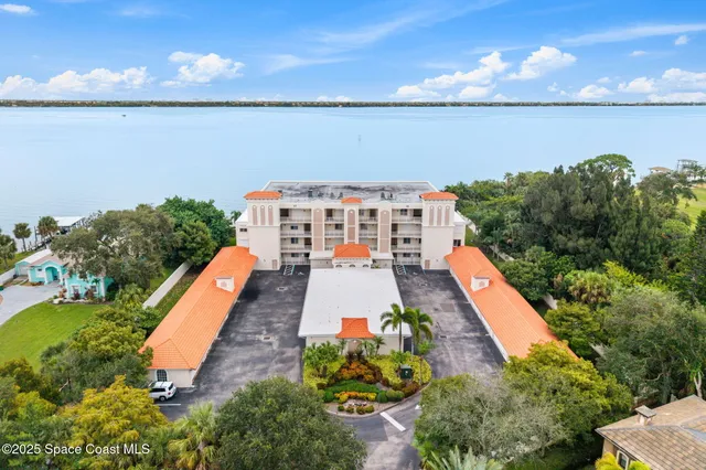 an aerial view of a house with a yard and lake view