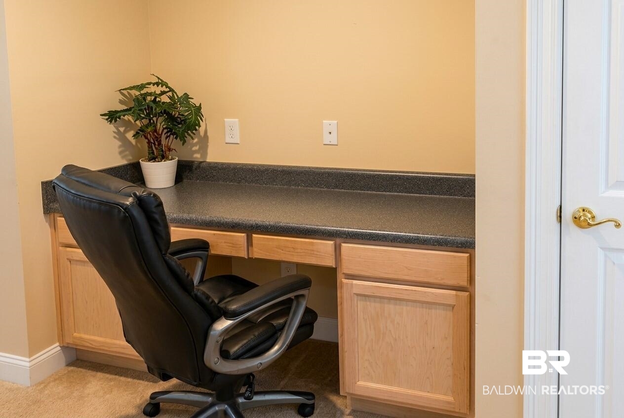 8008 Patricks Landing Road Bay Minette, AL 36507 - Photo 25 of 33 Built-in desk featuring a dark countertop, light wood-finish cabinetry, and neutral-toned wall paint