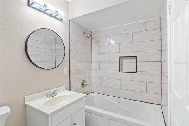a bathroom with a sink mirror toilet and bathtub