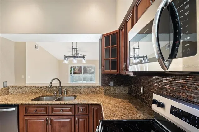 a kitchen with granite countertop a sink and a stove