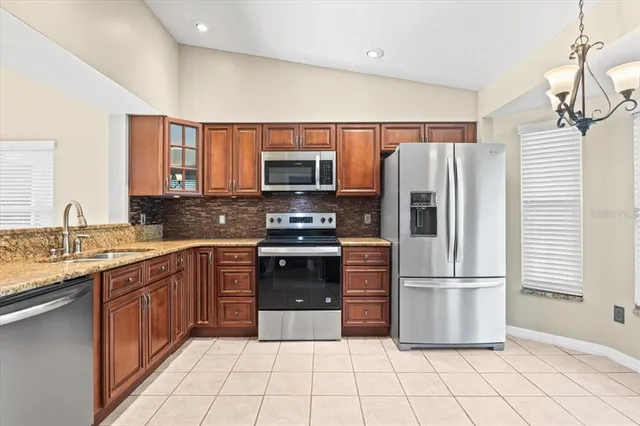 a kitchen with stainless steel appliances granite countertop a refrigerator and a stove top oven