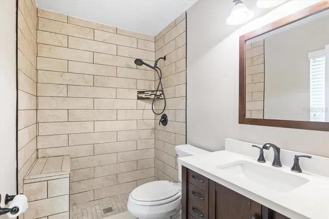 a bathroom with a sink a toilet and shower