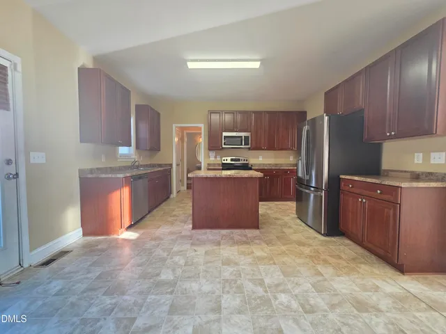 a kitchen with stainless steel appliances granite countertop a stove refrigerator and cabinets