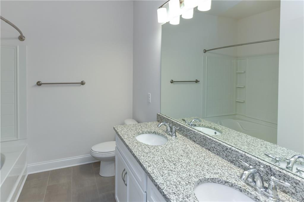5810 Carmel Road Charlotte, NC 28226 - Photo 28 of 31 a bathroom with a granite countertop sink a toilet and shower