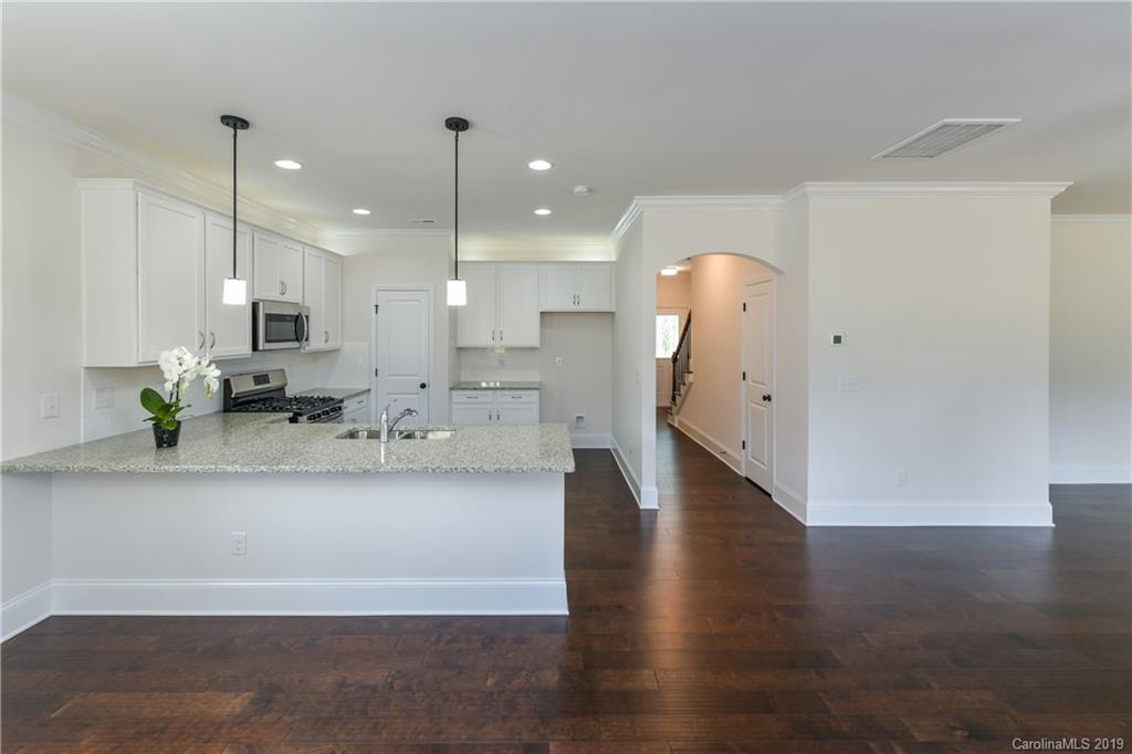 5810 Carmel Road Charlotte, NC 28226 - Photo 7 of 31 a view of a kitchen with kitchen island a sink stainless steel appliances and wooden floor