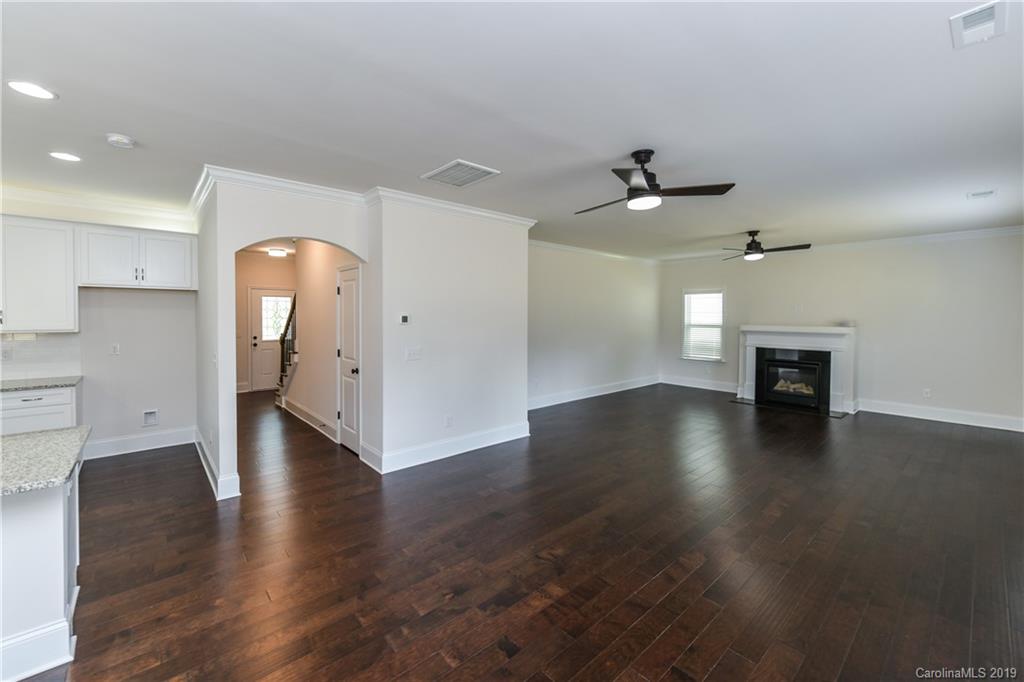 5810 Carmel Road Charlotte, NC 28226 - Photo 9 of 31 an empty room with wooden floor fireplace and windows