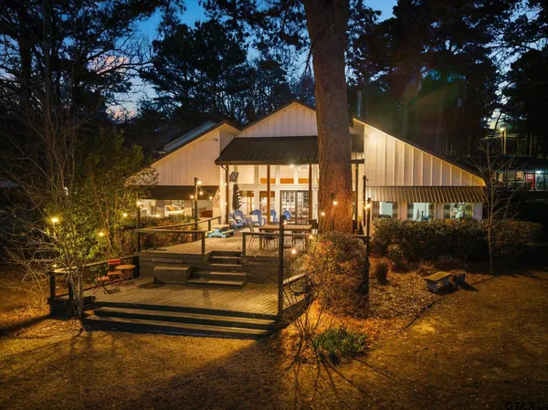a patio with table and chairs and potted plants