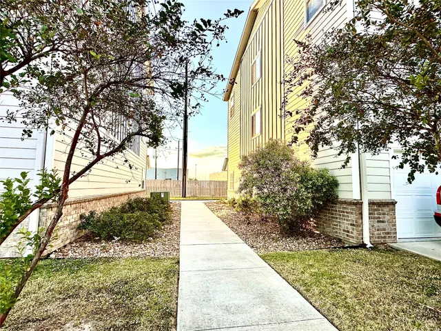 a view of a pathway of a house with large trees