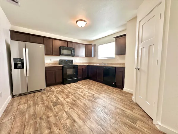a large kitchen with a refrigerator and a sink