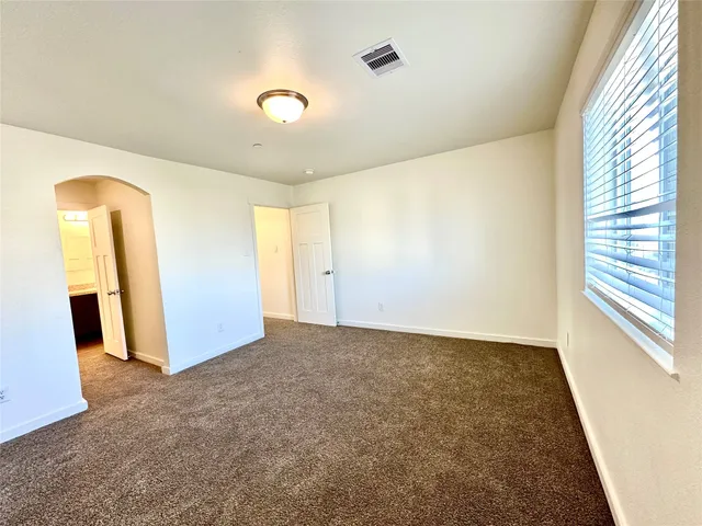 an empty room with windows and closet