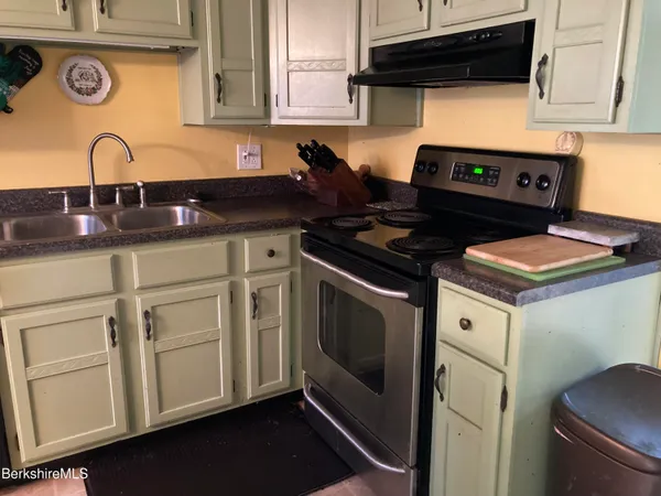 a kitchen with white cabinets and appliances
