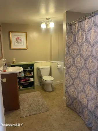 a bathroom with a sink a toilet and a mirror