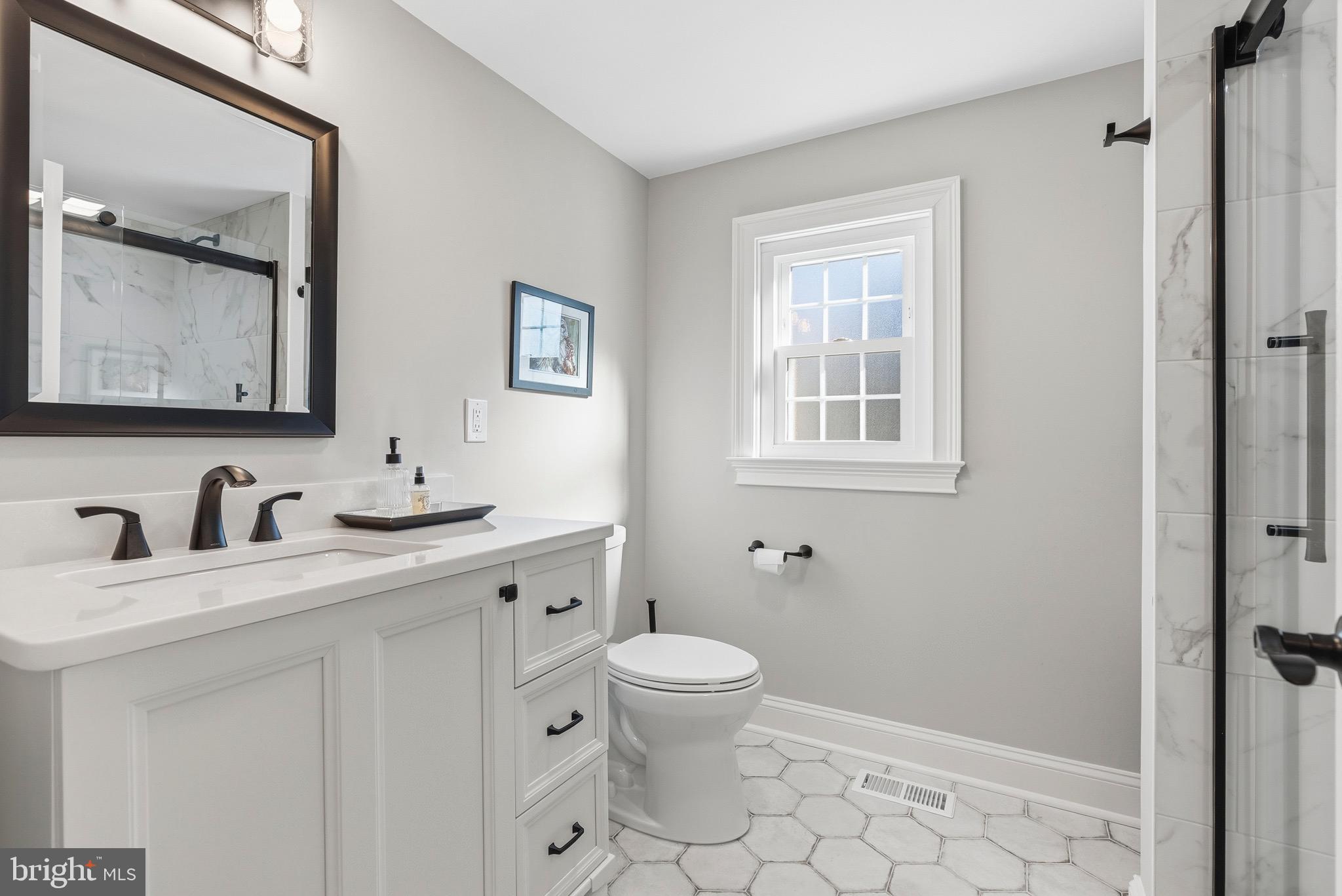 6837 White Rock Road Sykesville, MD 21784 - Photo 8 of 36 a bathroom with a toilet a sink a mirror a window and vanity