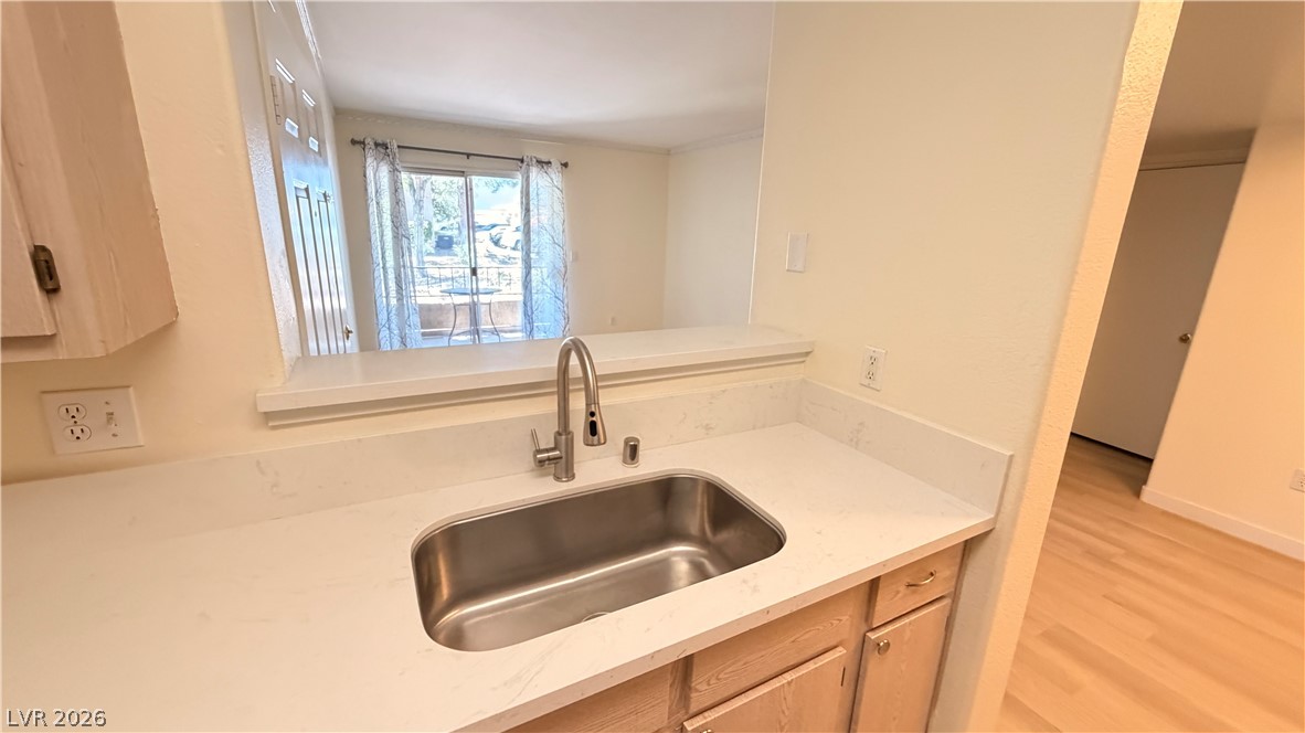 7885 West Flamingo Road, Unit 1131 Las Vegas, NV 89147 - Photo 19 of 36 A well-lit kitchen area features a stainless steel sink and light countertops.