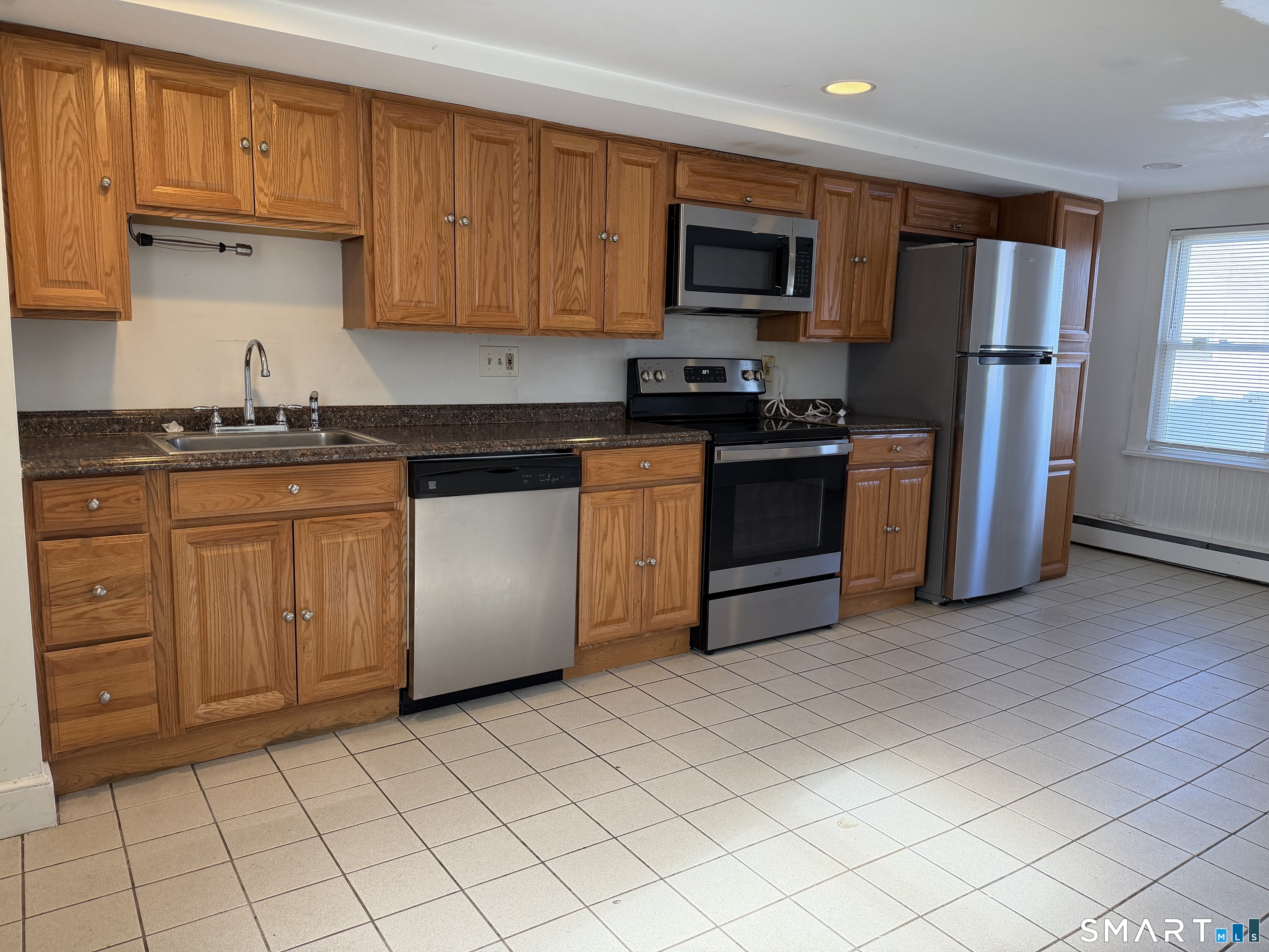 57 Chapel Street Wallingford, CT 06492 - Photo 3 of 18 a kitchen with stainless steel appliances granite countertop a stove a sink and a refrigerator