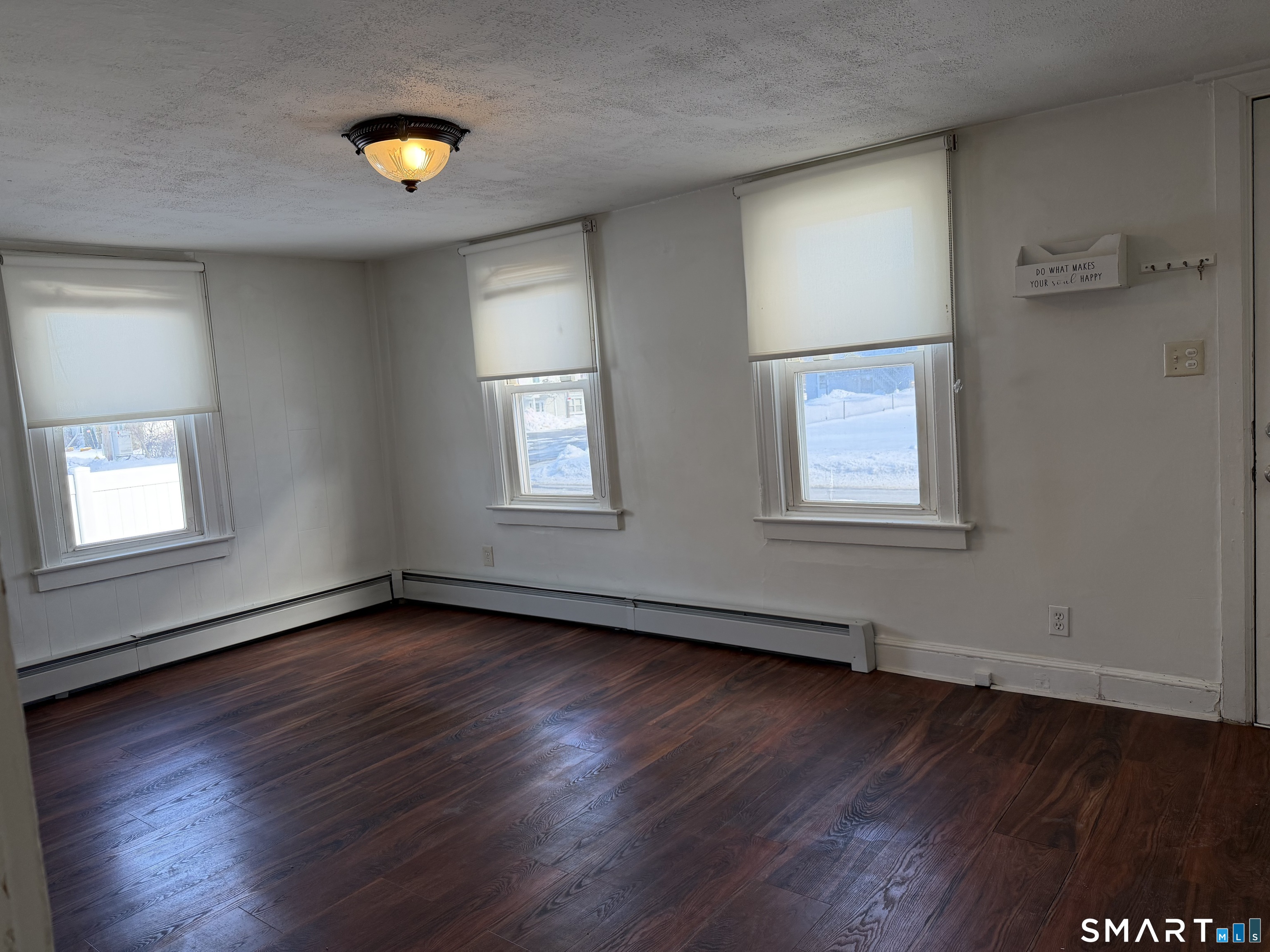 57 Chapel Street Wallingford, CT 06492 - Photo 8 of 18 an empty room with wooden floor and windows