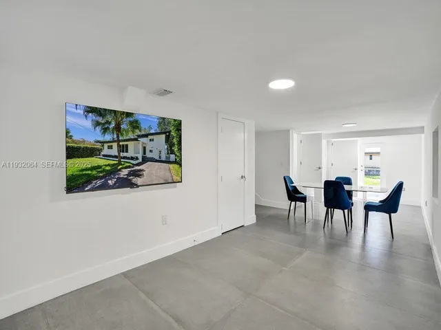 a dining room with furniture and a potted plant