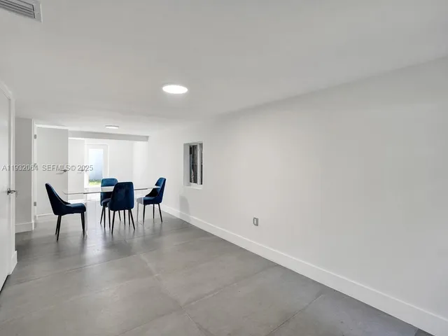 a view of a dining room with furniture and a potted plant