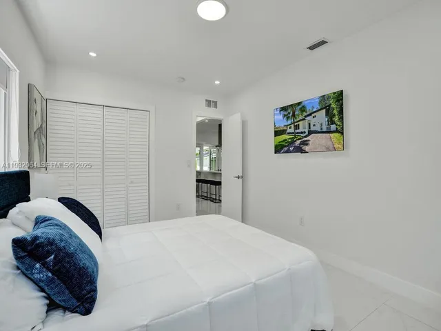 a bedroom with a bed and a painting on the wall